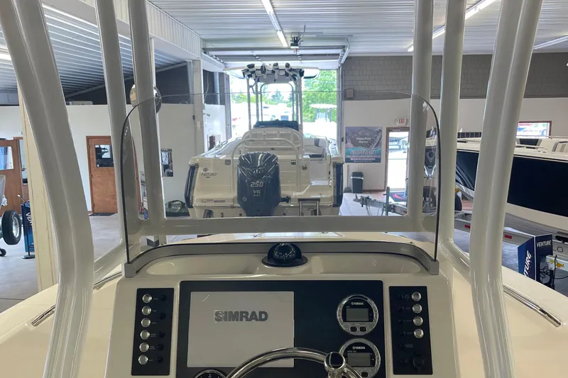 Slide: The Image of 2025 Robalo R180 Center Console boat interior with Simrad navigation system in showroom. - 8