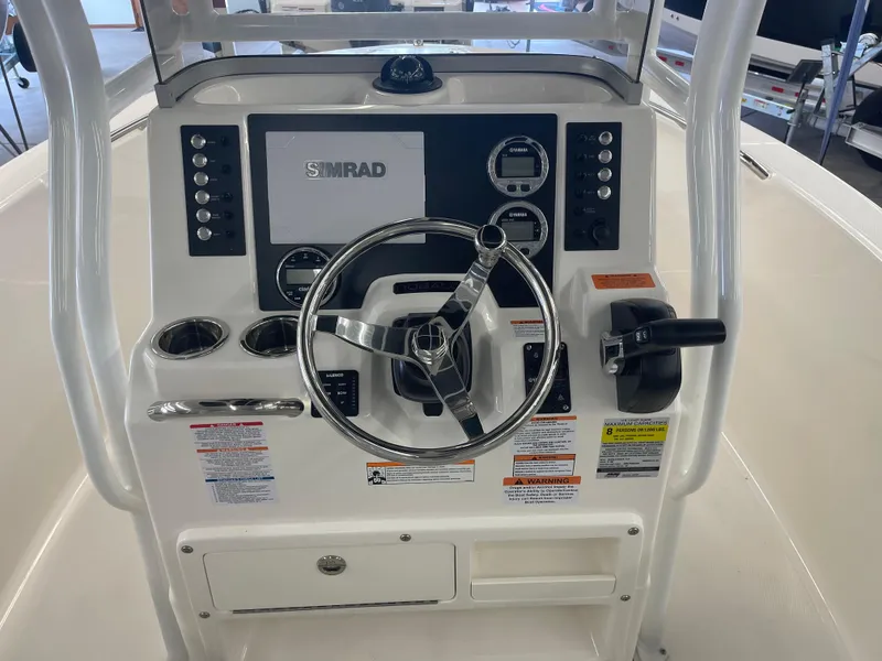Slide: The Image of 2025 Robalo R180 Center Console dashboard with steering wheel and Simrad display. - 9