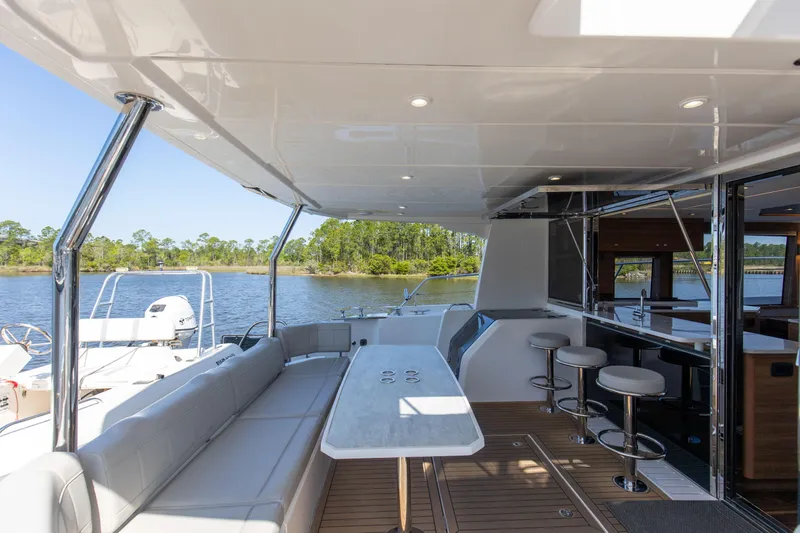 Slide: The Image of Luxurious 2022 Aquila 54 Yacht with spacious deck and modern seating by the water. - 13