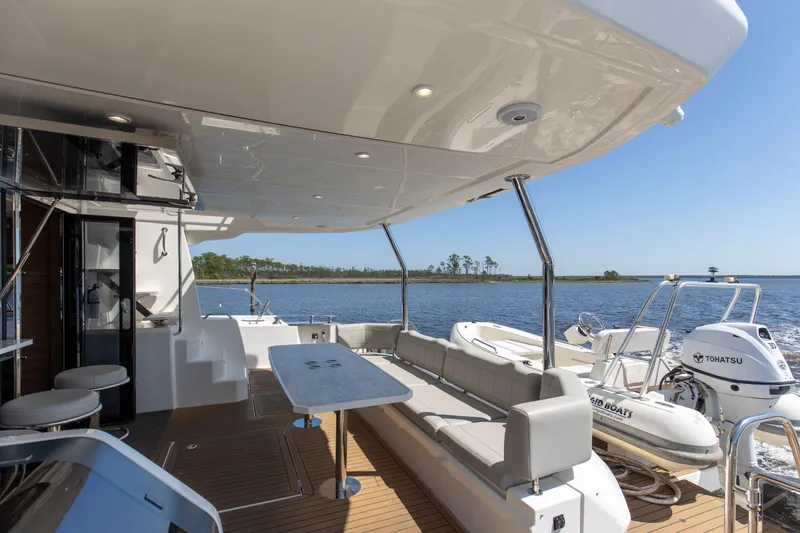 Slide: The Image of 2022 Aquila 54 Yacht deck with seating, table, and scenic water view. - 14