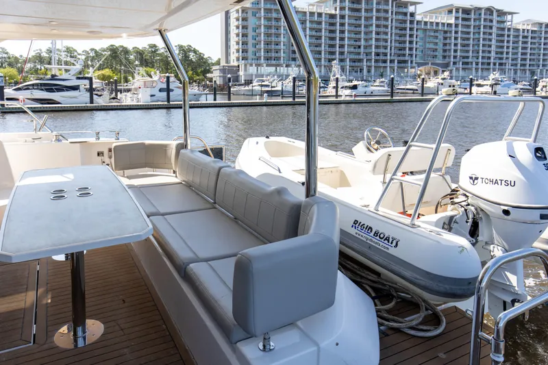 Slide: The Image of Aquila 54 Yacht 2022 with spacious deck, docked at marina with modern buildings. - 16