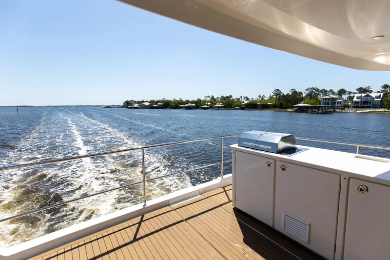 Slide: The Image of Aquila 54 Yacht 2022 cruising on a sunny day, featuring a sleek deck and outdoor kitchen. - 19