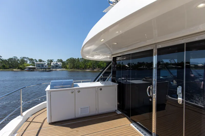 Slide: The Image of Aquila 54 Yacht 2022 deck with outdoor kitchen and scenic water view. - 20