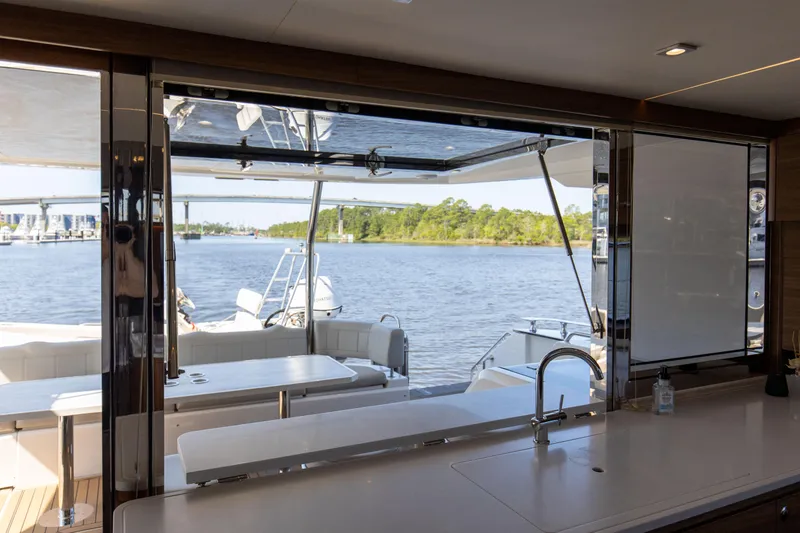 Slide: The Image of Interior view from Aquila 54 Yacht 2022, showcasing a scenic waterfront through large windows. - 27