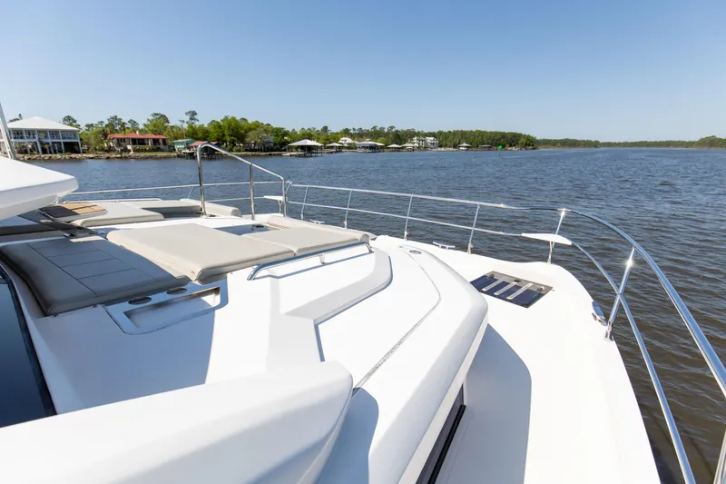 Slide: The Image of Aquila 54 Yacht 2022 on serene water, featuring spacious deck and luxurious seating. - 29