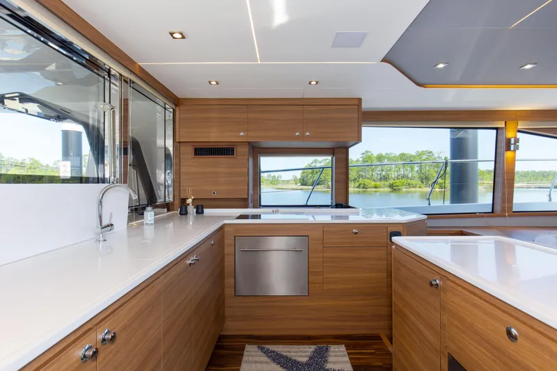 Slide: The Image of Luxurious kitchen interior of 2022 Aquila 54 Yacht with modern wood cabinetry and scenic window view. - 34