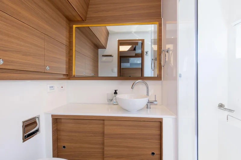 Slide: The Image of Modern bathroom interior on 2022 Aquila 54 Yacht, featuring wood accents and sleek fixtures. - 49
