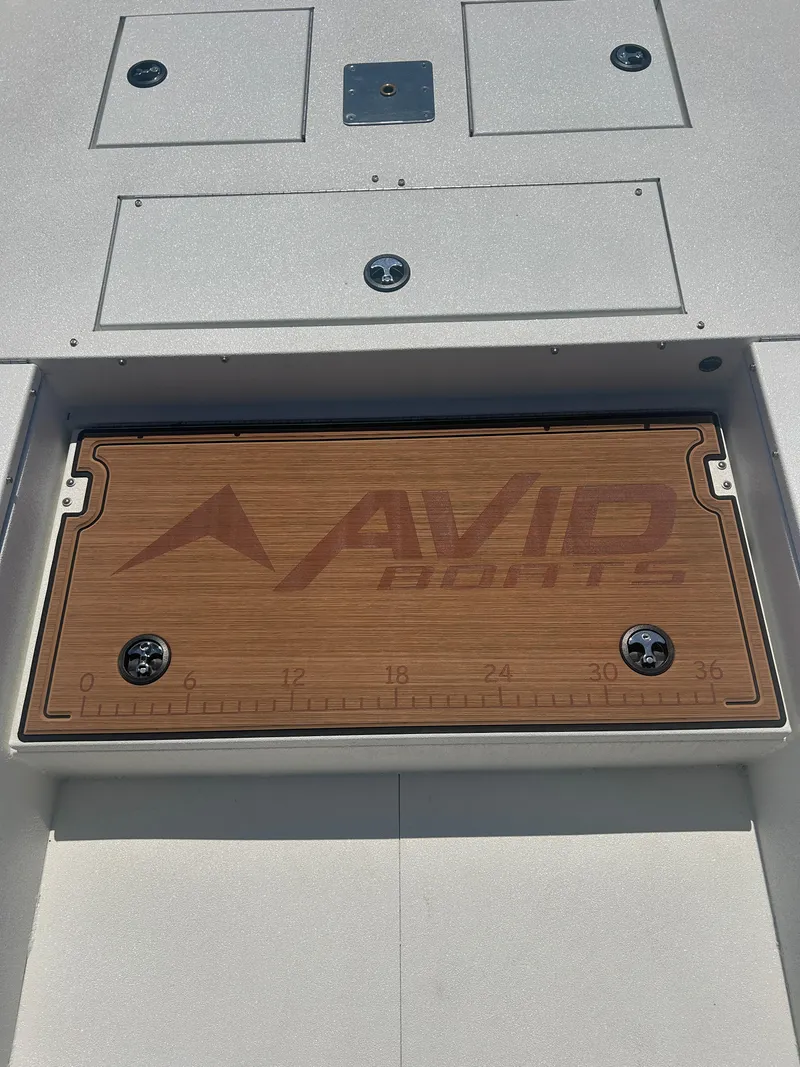Slide: The Image of Avid 22 Recon 2025 boat deck with branded wooden panel and measurement markings. - 15