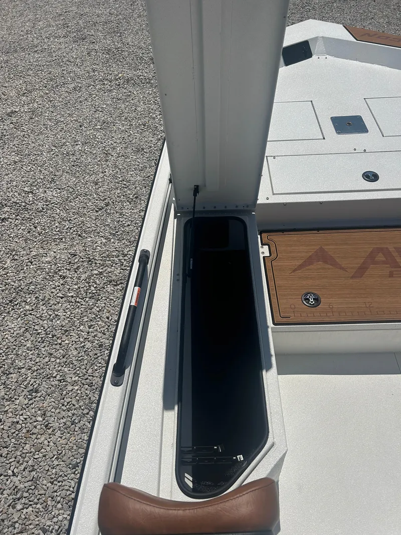 Slide: The Image of 2025 Avid 22 Recon boat interior with storage compartment and brown seat. - 18