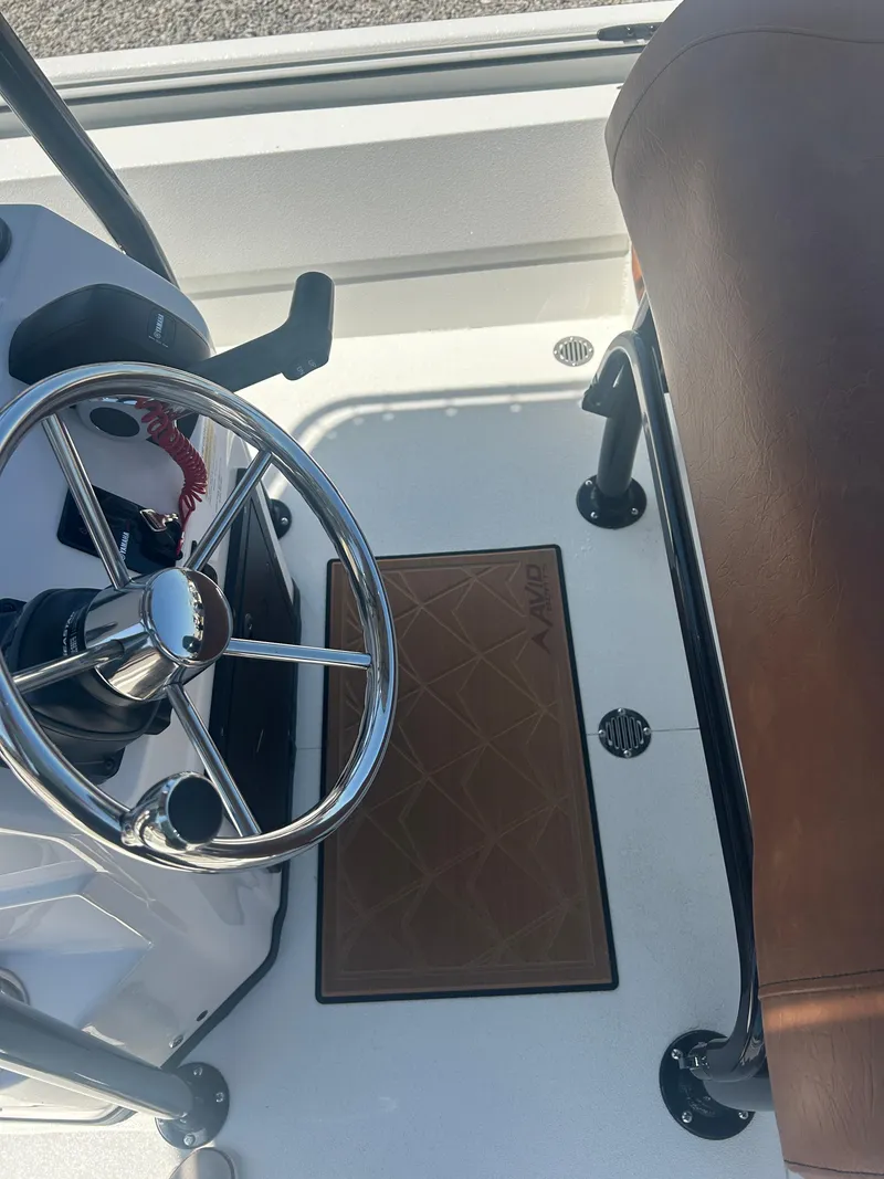 Slide: The Image of Steering area of 2025 Avid 22 Recon boat with brown seating and mat. - 23