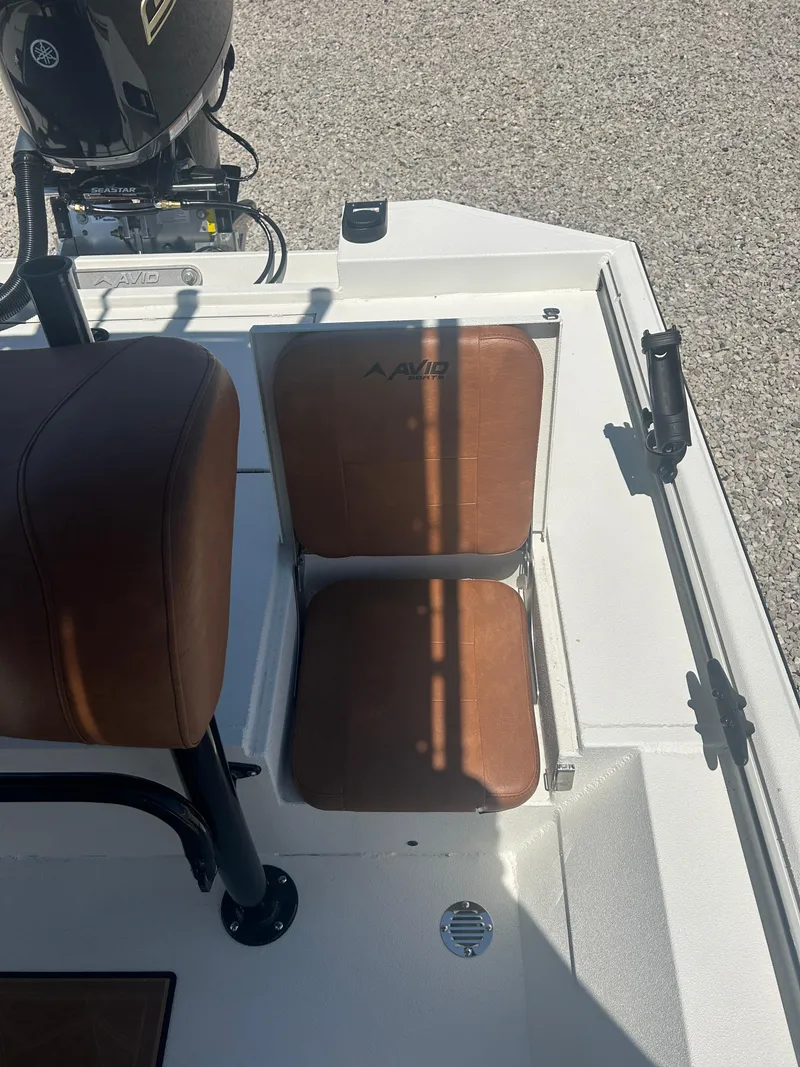 Slide: The Image of 2025 Avid 22 Recon boat seats with brown cushions and motor in background. - 24