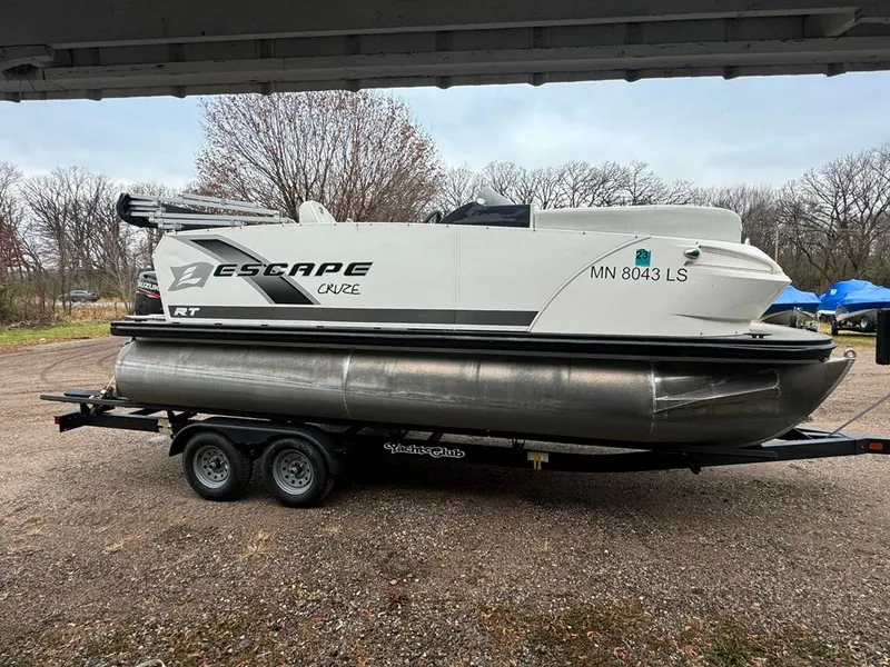 Slide: The Image of 2017 Larson Escape Cruze pontoon boat on trailer, parked outdoors. - 0