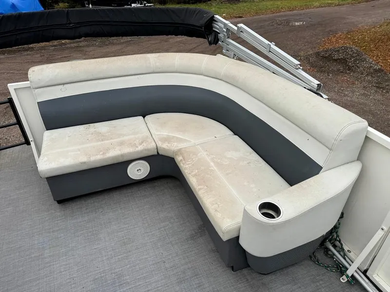 Slide: The Image of 2017 Larson Escape Cruze boat seating with cup holder, featuring white and gray upholstery. - 10