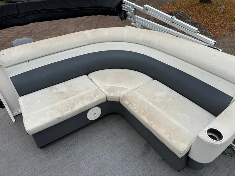 Slide: The Image of 2017 Larson Escape Cruze boat seating with cup holder, featuring white and gray upholstery. - 13