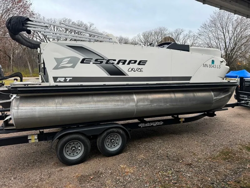 Slide: The Image of 2017 Larson Escape Cruze pontoon boat on trailer, parked outdoors. - 7