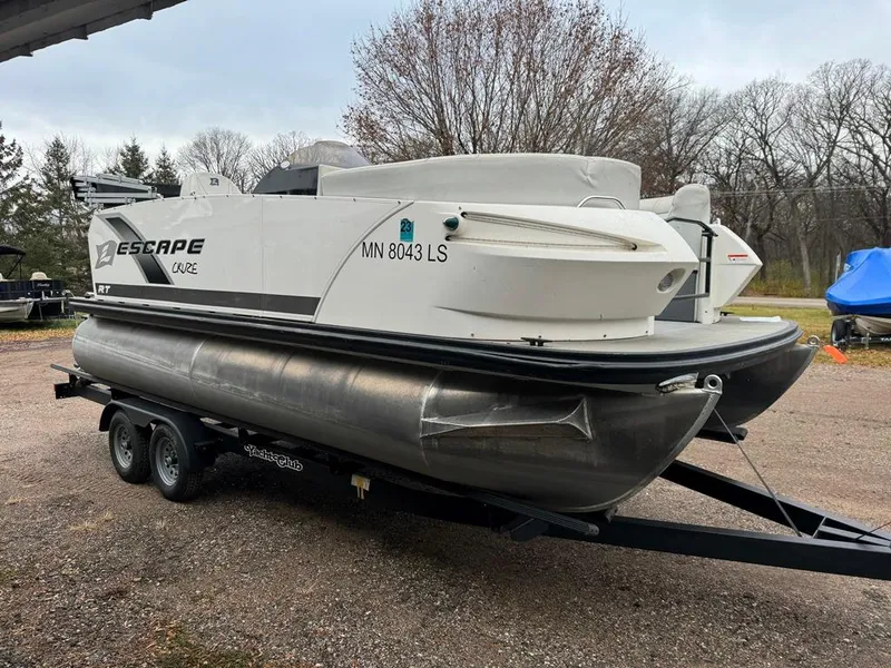 Slide: The Image of 2017 Larson Escape Cruze pontoon boat on trailer, parked outdoors. - 8