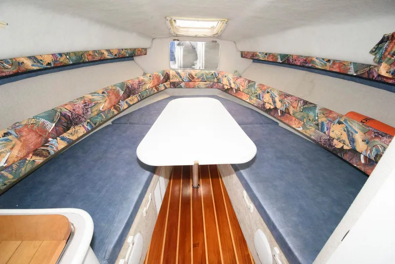 Slide: The Image of Interior of a 1995 Monterey 246 SEL cruiser with colorful seating and a central table. - 10