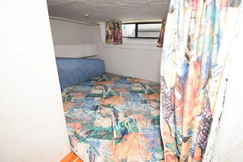 Slide: The Image of Cozy cabin interior of 1995 Monterey 246 SEL cruiser with colorful bedding and curtains. - 11