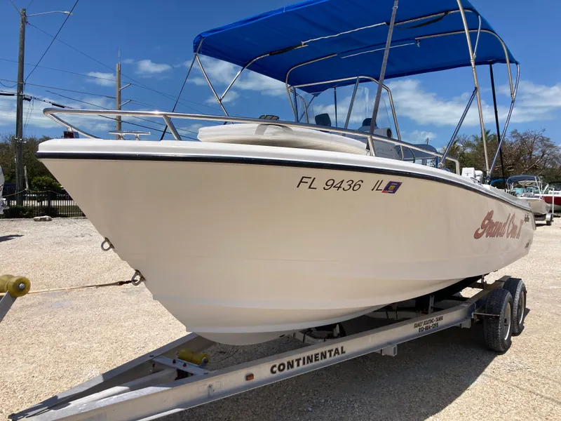 Slide: The Image of 2007 Edgewater 205CC boat on trailer with blue canopy, parked outdoors. - 5