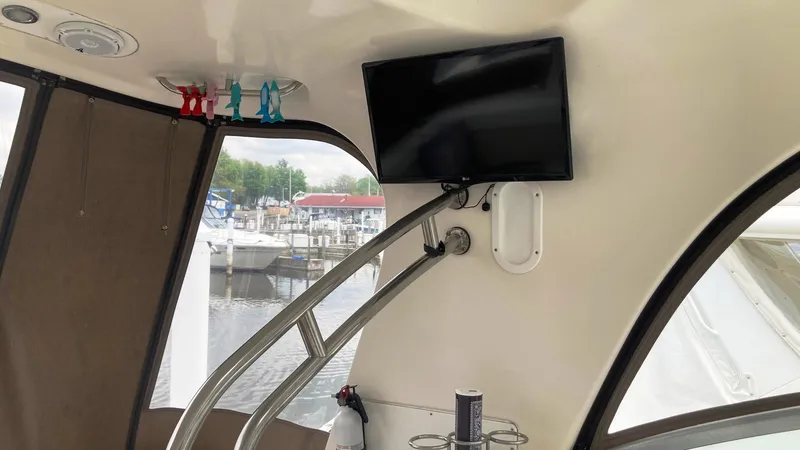 Slide: The Image of 2008 Rinker 400 Express Cruiser interior with mounted TV and marina view. - 13