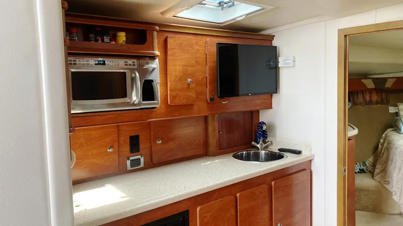 Slide: The Image of 2008 Rinker 400 Express Cruiser interior with kitchenette, microwave, and TV. - 16
