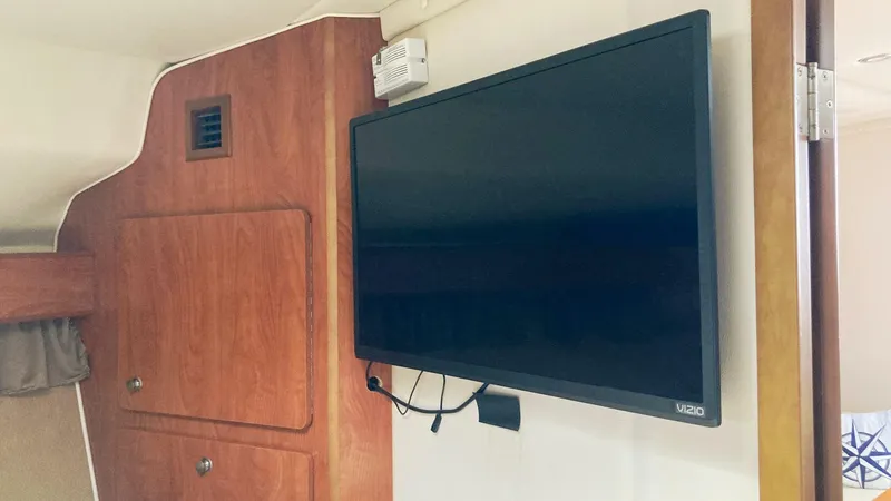 Slide: The Image of Flat-screen TV inside 2008 Rinker 400 Express Cruiser cabin, mounted on wooden wall. - 22