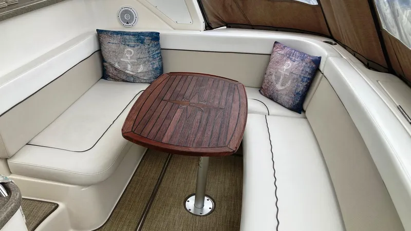 Slide: The Image of 2008 Rinker 400 Express Cruiser interior with cushioned seating and wooden table. - 4