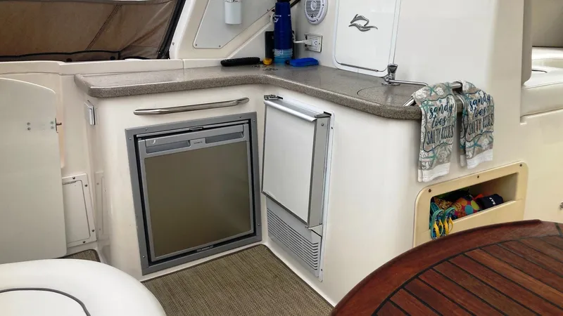 Slide: The Image of 2008 Rinker 400 Express Cruiser interior with kitchenette, featuring fridge and sink. - 7