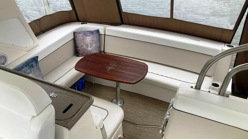 Slide: The Image of 2008 Rinker 400 Express Cruiser interior with white seating and wooden table. - 8