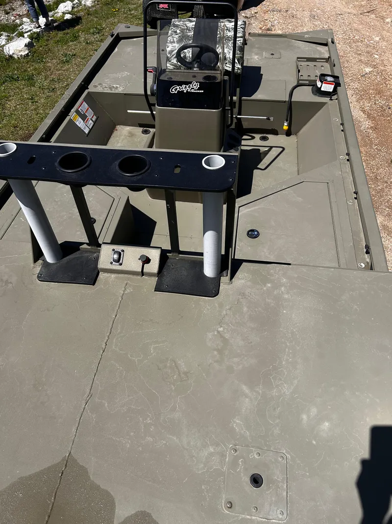 Slide: The Image of 2024 Tracker Grizzly 2072 CC Sportsman boat interior with console and rod holders. - 12