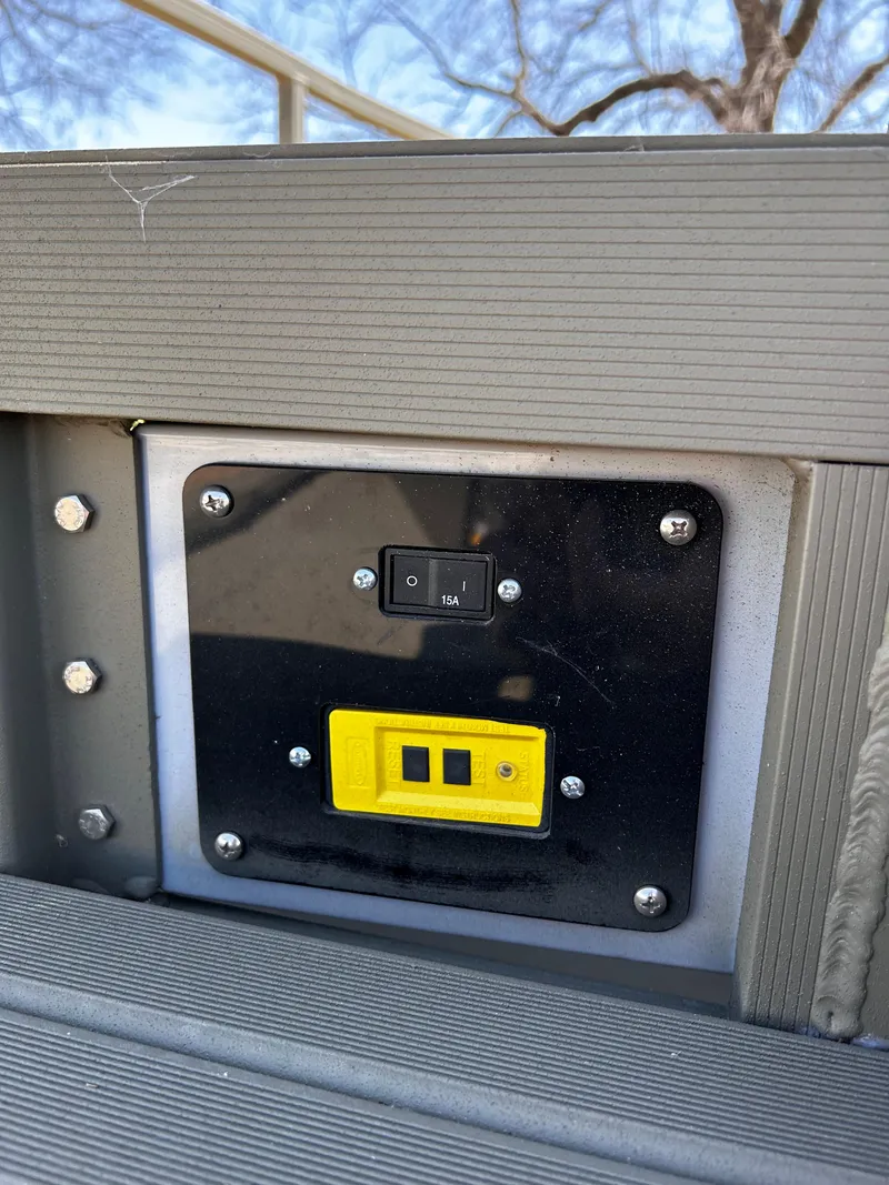 Slide: The Image of 2024 Tracker Grizzly 2072 CC Sportsman control panel with switches and yellow outlet. - 14