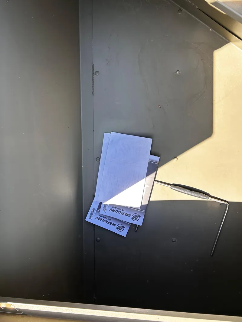 Slide: The Image of 2024 Tracker Grizzly 2072 CC Sportsman interior with documents and tool. - 17