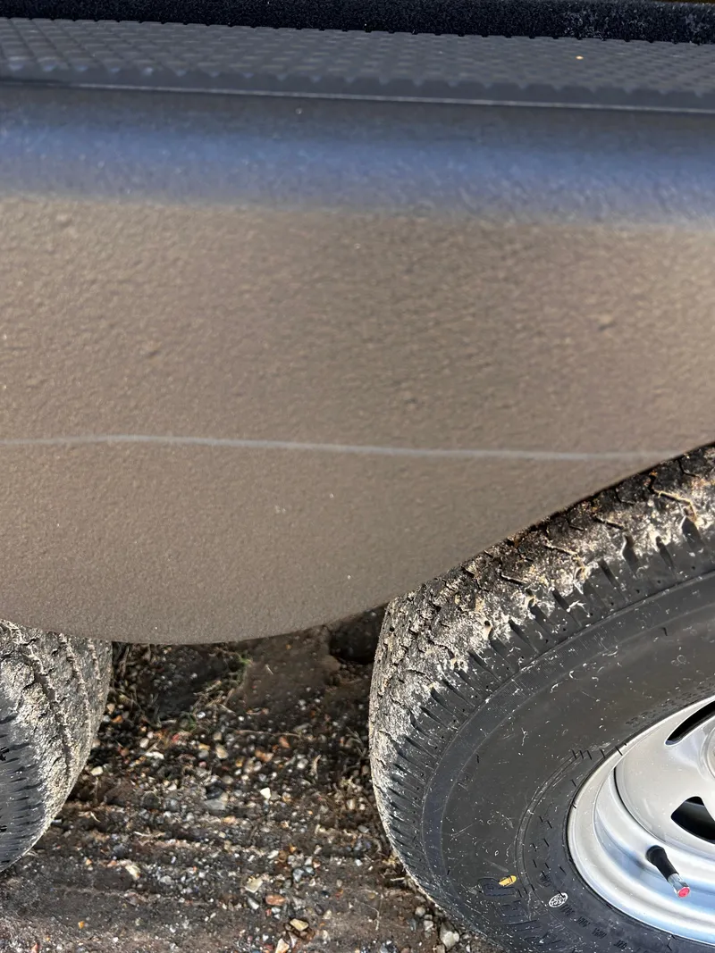 Slide: The Image of 2024 Tracker Grizzly 2072 CC Sportsman boat trailer tire and hull detail. - 5