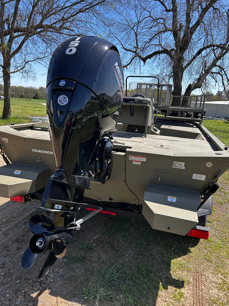 Slide: The Image of 2024 Tracker Grizzly 2072 CC Sportsman boat with powerful outboard motor, parked outdoors. - 7
