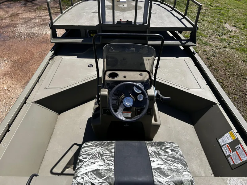Slide: The Image of 2024 Tracker Grizzly 2072 CC Sportsman boat interior with steering console and camouflage seat. - 9