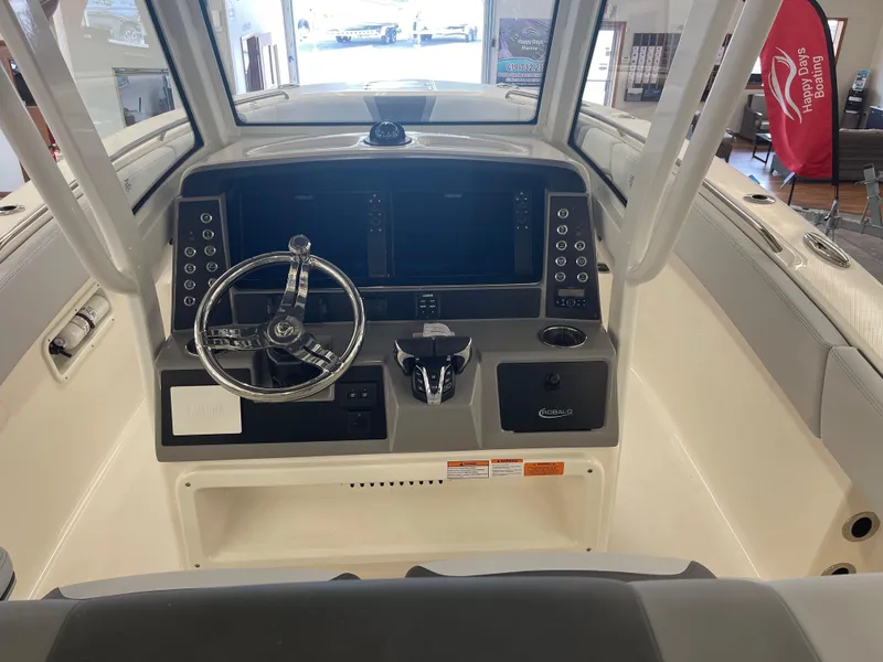 Slide: The Image of 2025 Robalo R270 Center Console boat dashboard with steering wheel and control panel. - 10