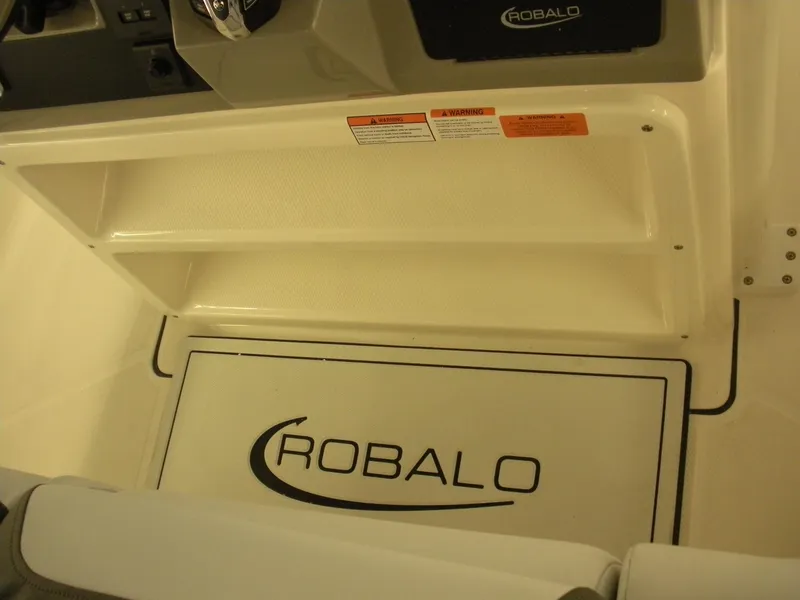 Slide: The Image of 2025 Robalo R270 Center Console interior with branded flooring and storage compartments. - 12