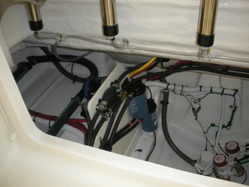 Slide: The Image of 2025 Robalo R270 Center Console boat engine compartment with wiring and hoses. - 19