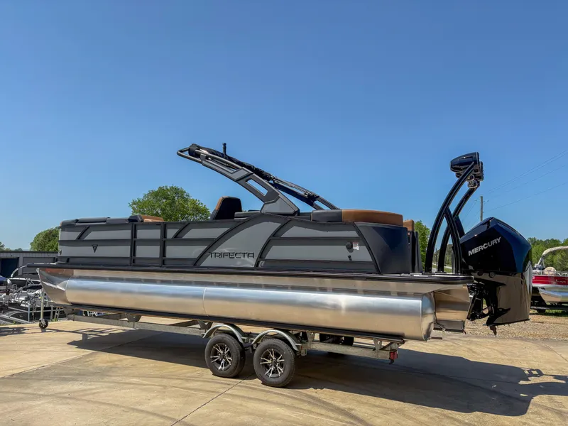 Slide: The Image of 2025 Trifecta 25 RF SS pontoon boat on trailer, featuring sleek design and Mercury outboard motor. - 1