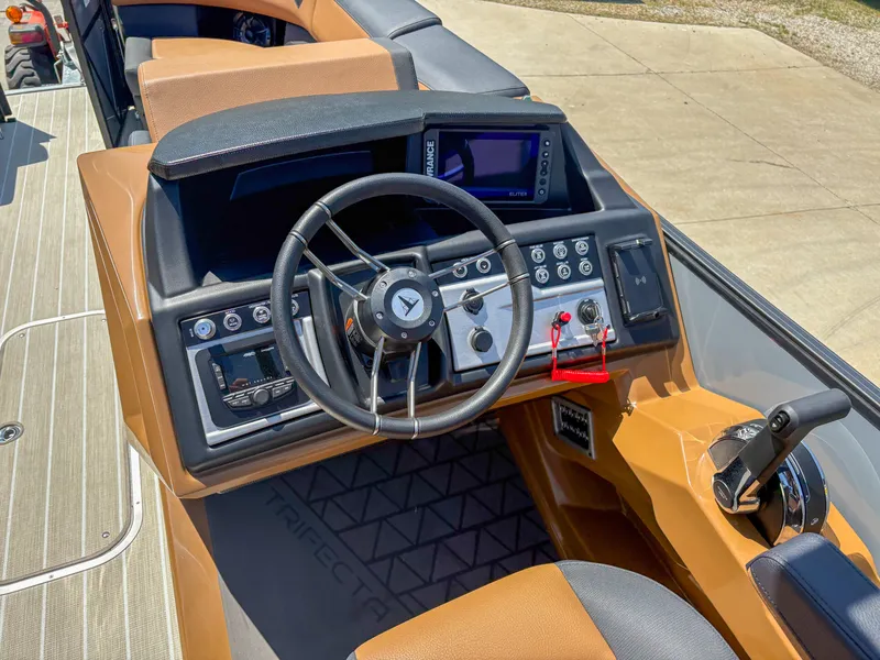 Slide: The Image of 2025 Trifecta 25 RF SS boat dashboard with steering wheel and control panel. - 8