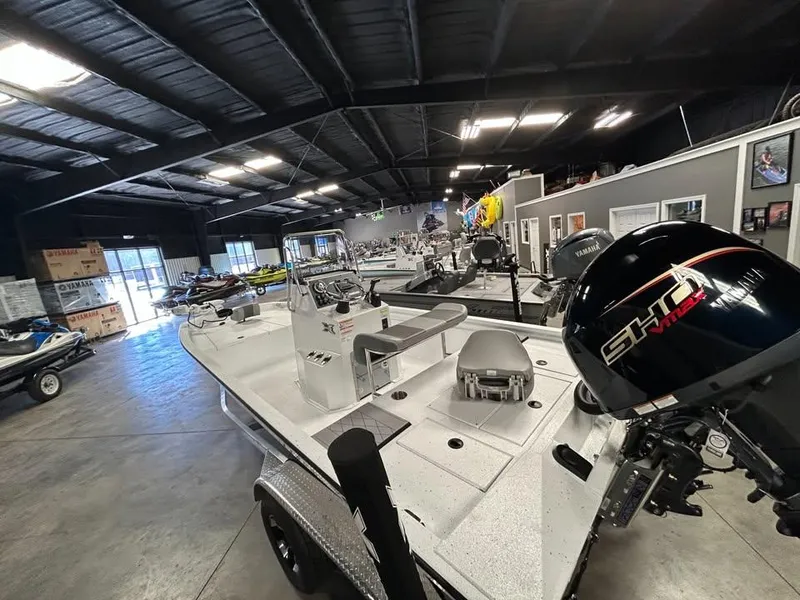 Slide: The Image of 2025 Xpress H 210 Bay boat displayed in a showroom with various marine equipment. - 4