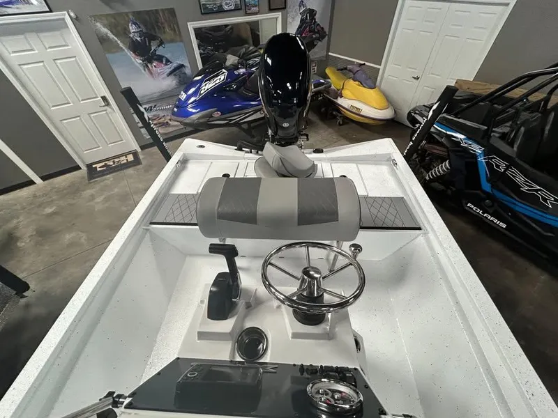 Slide: The Image of 2025 Xpress H 210 Bay boat interior with steering wheel and controls in a showroom. - 5