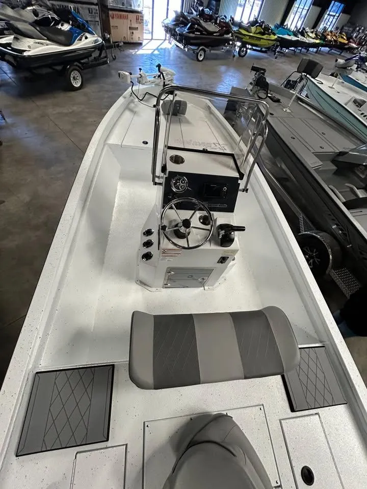 Slide: The Image of 2025 Xpress H 210 Bay boat interior with steering console and seating, displayed in showroom. - 6