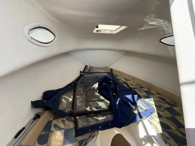 Slide: The Image of Interior cabin of 2008 Pro-Line 20 Express boat with windows and stored equipment. - 12