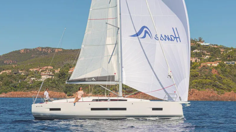 Slide: The Image of 2025 Hanse 410 sailboat cruising on a scenic coastal waterway. - 11