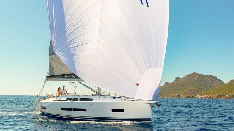 Slide: The Image of 2025 Hanse 410 sailboat cruising on open water with scenic coastal backdrop. - 13