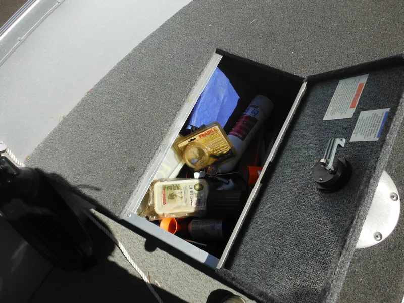 Slide: The Image of Storage compartment in 2006 Alumacraft Lunker 165 LTD CS boat with various items inside. - 12