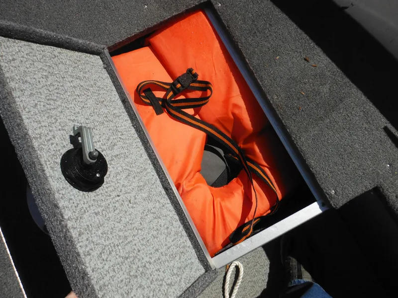 Slide: The Image of Storage compartment in 2006 Alumacraft Lunker 165 LTD CS boat with orange life jacket. - 13
