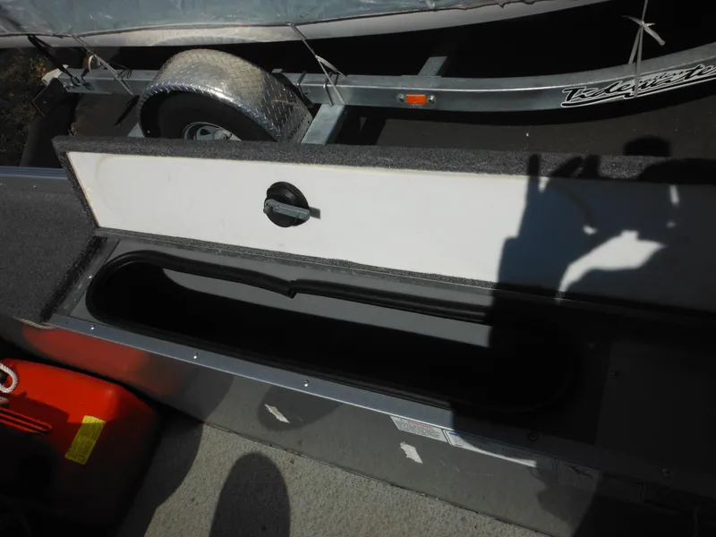 Slide: The Image of 2006 Alumacraft Lunker 165 LTD CS boat storage compartment with open lid, trailer visible. - 18