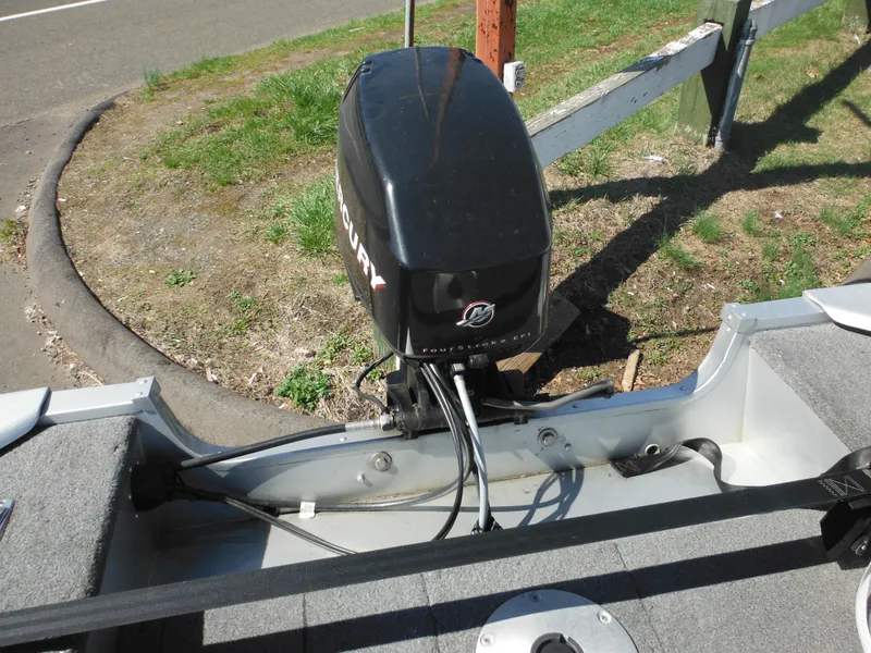 Slide: The Image of 2006 Alumacraft Lunker 165 LTD CS boat with Mercury outboard motor, parked on grass. - 23